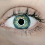 person showing green and black eyelid closeup photography